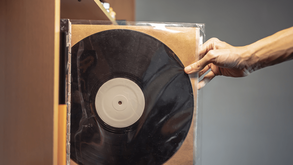 Hand taking vinyl album off shelf